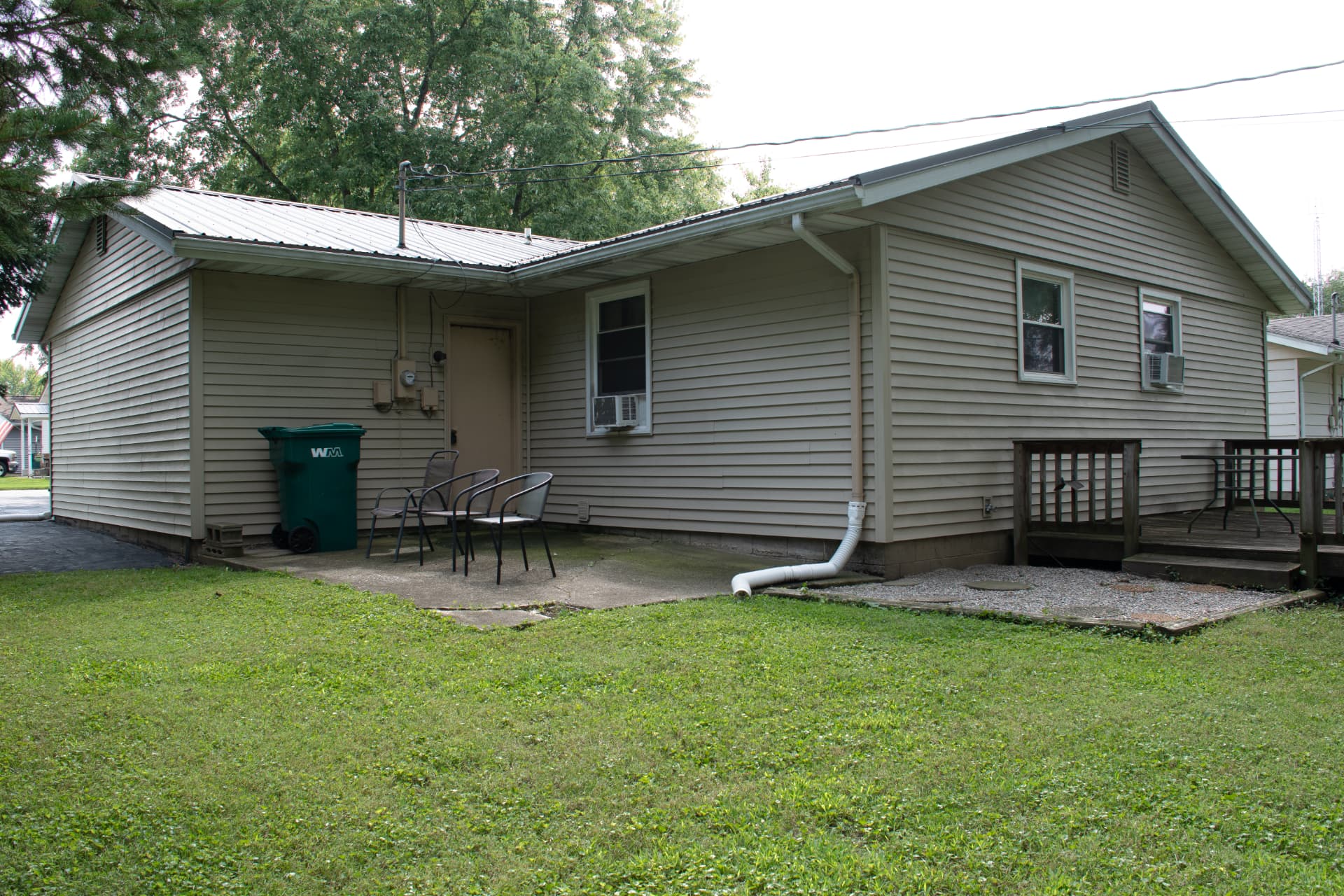 Rear exterior of the home with concrete patio and seating