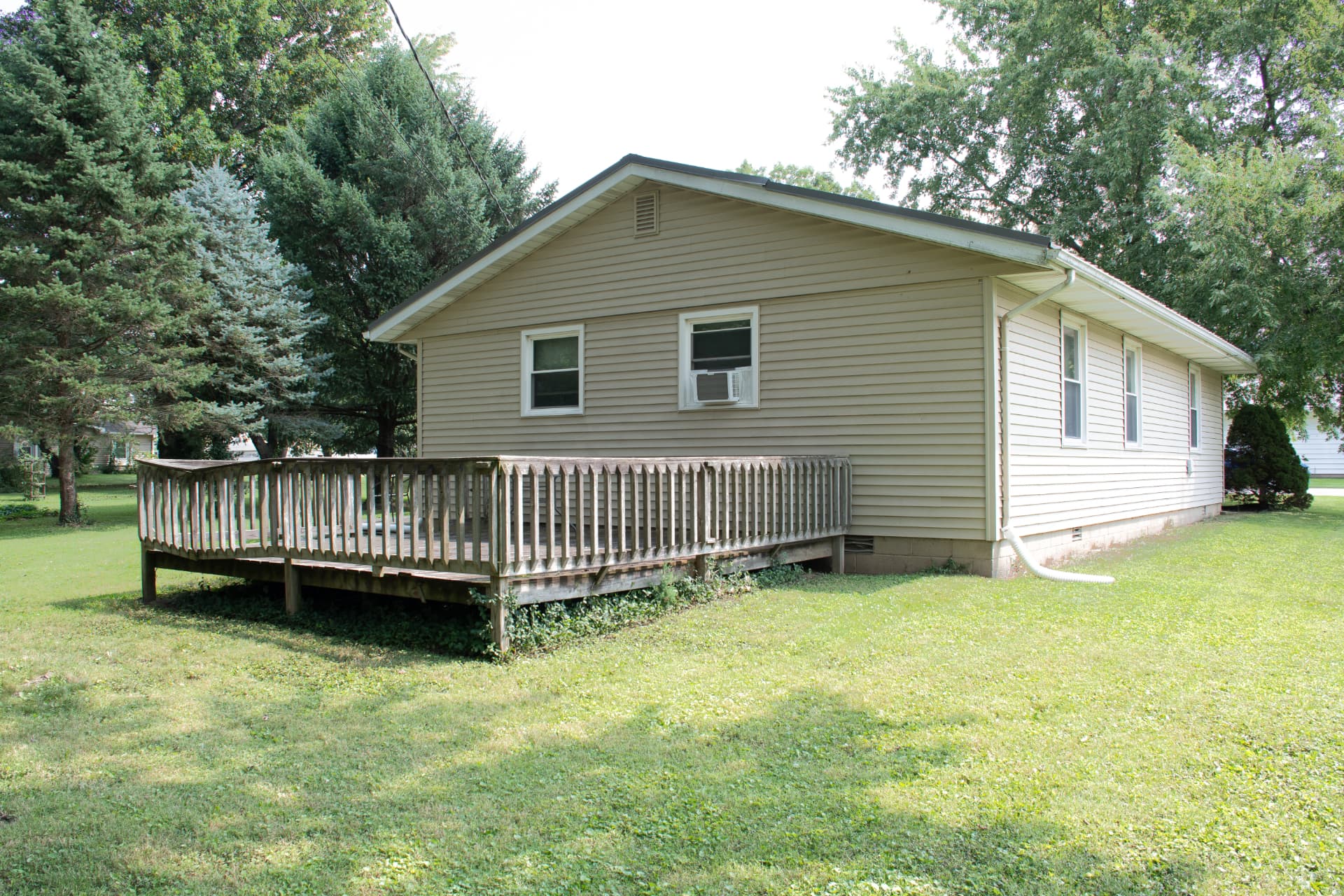 Side elevation of the home with the deck and open lawn